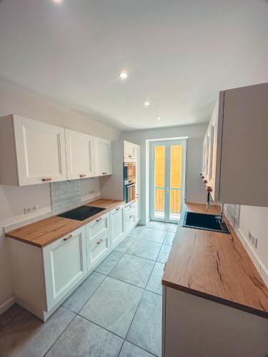 une cuisine avec des armoires blanches et un comptoir en bois dans l'établissement Liviamariasanta, à Ajaccio