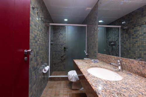 y baño con lavabo y ducha. en Rede Andrade LG Inn, en Recife
