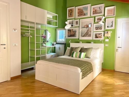 热那亚Carabaghe Style - attico Genova centro storico - acquario - rolli - caruggi - wifi - smart working的卧室拥有绿色的墙壁和白色的床。