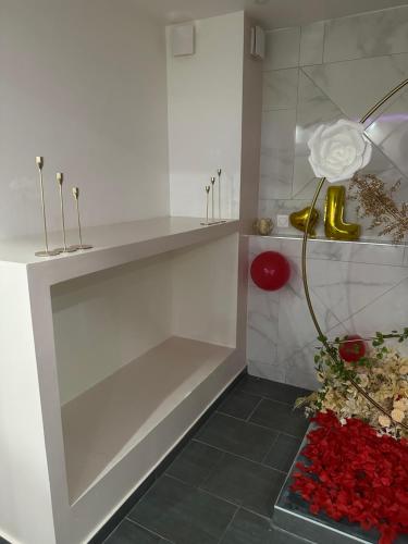 a white room with a vase with a flower in it at LovRoom deco Re & Spacieux in Ris-Orangis
