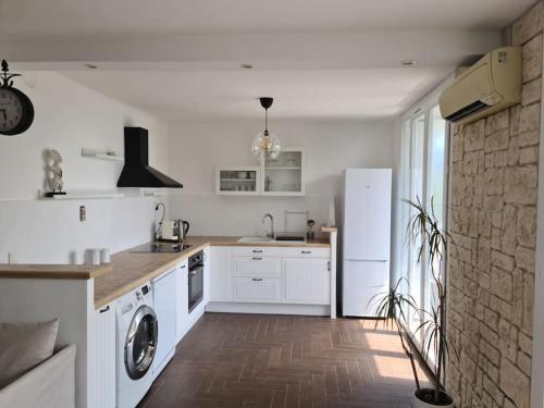 une cuisine avec des armoires blanches et un réfrigérateur blanc dans l'établissement LES SABLETTES LES PIEDS dans L'EAU, à La Seyne-sur-Mer