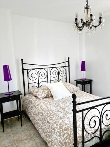 - une chambre avec un lit noir, deux tables et deux lampes dans l'établissement LES SABLETTES LES PIEDS dans L'EAU, à La Seyne-sur-Mer