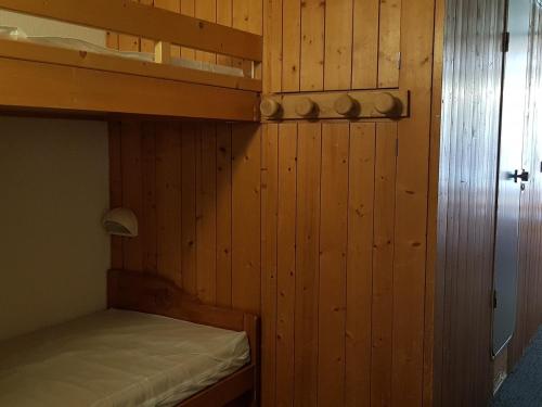 - une chambre avec des lits superposés et des murs en bois dans l'établissement Appartement 7 pers. avec balcon skis aux pieds, proche commerces et télésièges - Arc 1800 - FR-1-411-240, à Arc 1800