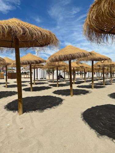 a group of straw umbrellas on a beach at Casa deBoer in Jávea