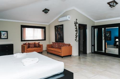 1 dormitorio con 1 cama blanca y 2 sillas en Hotel Brisa en Punta Cana