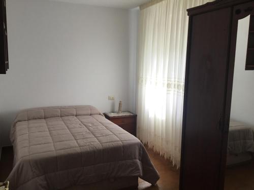 a bedroom with a bed and a window at Curruncho in Camariñas