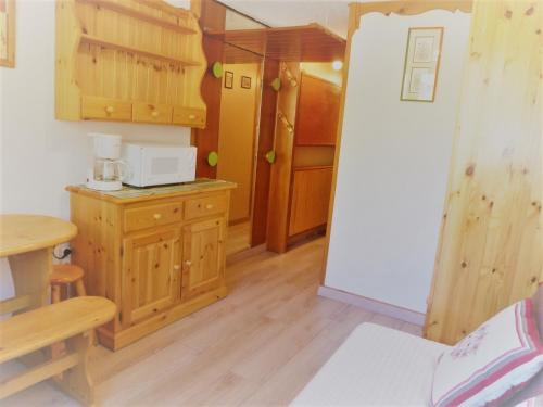 - une petite cuisine avec des placards en bois et un four micro-ondes dans l'établissement Studio cosy pour 2 à Tignes, pied des pistes et commerces - FR-1-411-488, à Tignes