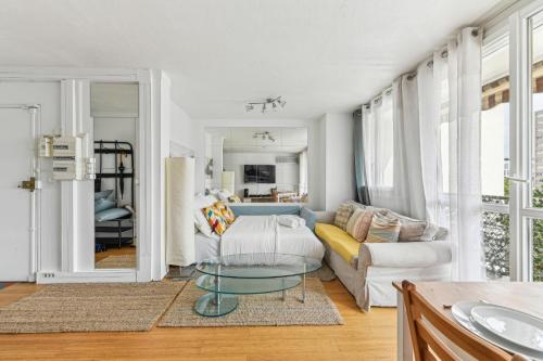 een woonkamer met een bank en een tafel bij Chic and comfortable apart with balcony in Levallois-Perret
