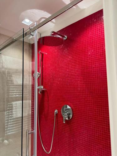a shower with a red tiled wall in a bathroom at Delle Nazioni Milan Hotel in Milan