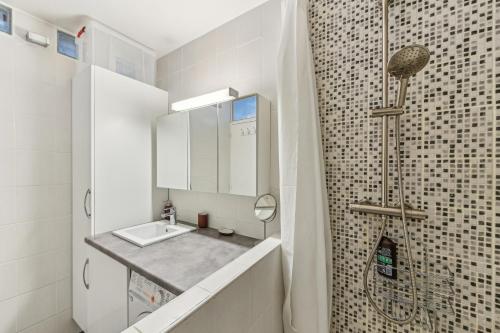 een badkamer met wastafel en douche bij Chic and comfortable apart with balcony in Levallois-Perret