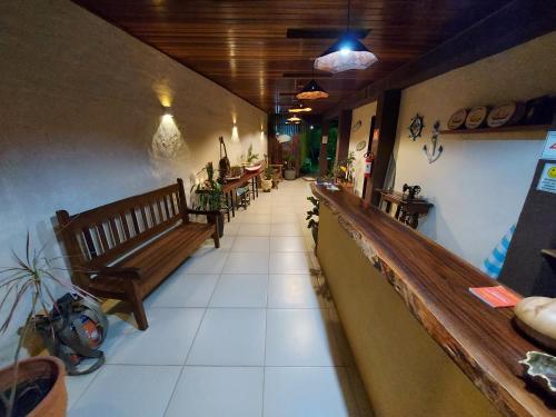 a hallway with benches and tables in a restaurant at Pousada Refugio Prumirim in Ubatuba
