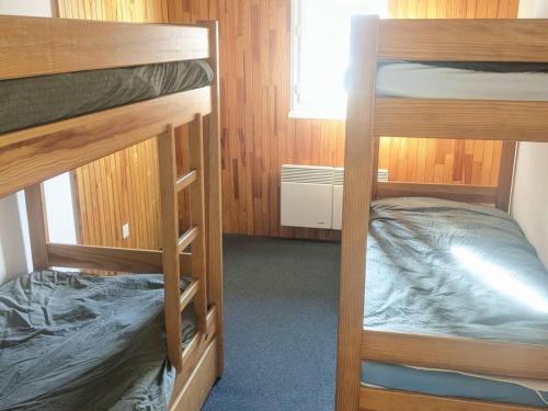 une chambre avec deux lits superposés et une fenêtre dans l'établissement 2 pièces au pied des pistes avec balcon et cuisine équipée - FR-1-557-110, à Les Adrets