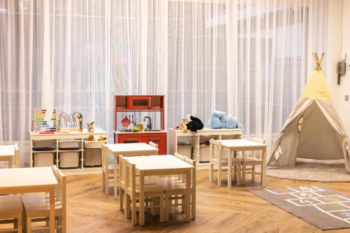 a childs room with tables and chairs and a tent at Lielupe Hotel SPA & Conferences by Semarah in Jūrmala