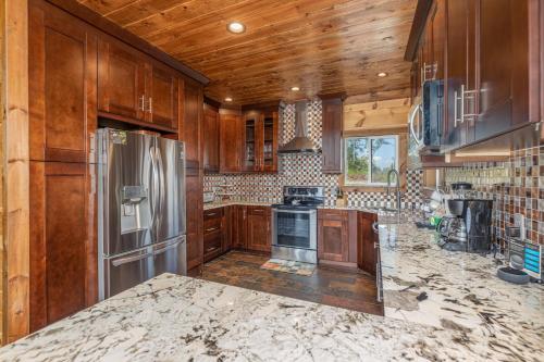 a kitchen with wooden cabinets and a stainless steel refrigerator at A Plus Amazing Views by Eden Crest in Gatlinburg