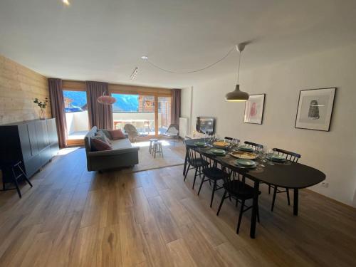 un salon avec une table, des chaises et un canapé dans l'établissement Crémaillère A101 - Multipass inclu, à Châtel