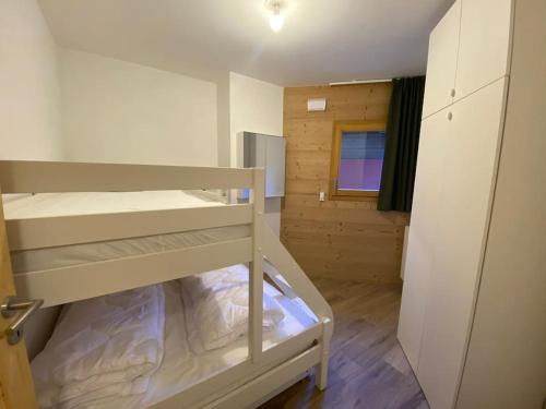 une petite chambre avec deux lits superposés et une fenêtre dans l'établissement Crémaillère A101 - Multipass inclu, à Châtel