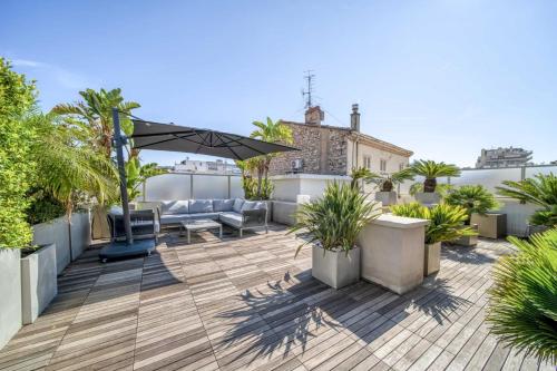 une terrasse sur le toit avec des meubles et des plantes sur un toit dans l'établissement Cannes Luxury Rental - Penthouse, à Cannes