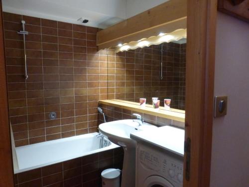 une salle de bain avec un lavabo et une baignoire dans l'établissement Studio confortable à Méribel Altiport, skis aux pieds, terrasse ensoleillée, proche forêt - FR-1-411-835, à Les Allues