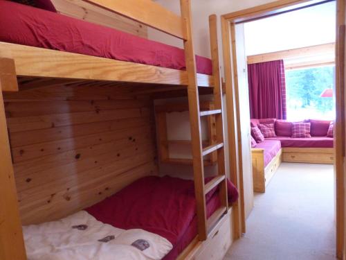 une chambre avec deux lits superposés et un canapé dans l'établissement Studio confortable à Méribel Altiport, skis aux pieds, terrasse ensoleillée, proche forêt - FR-1-411-835, à Les Allues