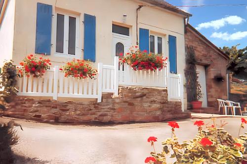une maison avec volets bleus et fleurs rouges devant dans l'établissement Maison de 2 chambres avec vue sur le lac jardin amenage et wifi a Chateaulin, à Châteaulin