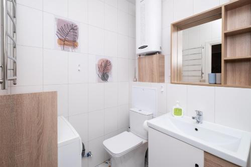a white bathroom with a toilet and a sink at Апартаменты Sweet Home in Kazan