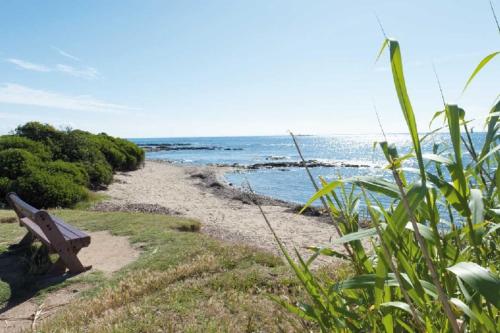 un banc assis sur le côté d'une plage dans l'établissement Beautiful apartment in the center of town, à Sainte-Maxime