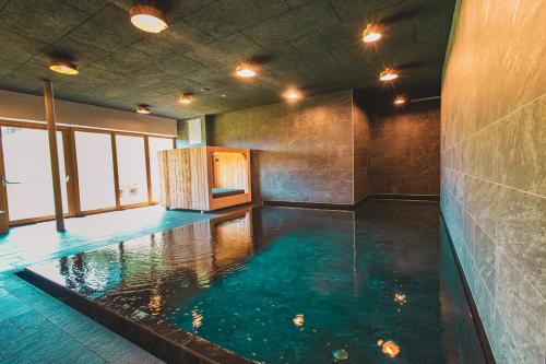 a large indoor swimming pool with blue water at Bio Natur Refugium Blaslahof **** in Valle Di Casies