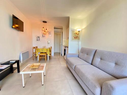 un salon avec un canapé et une table dans l'établissement Le Chagall By SCLS Locations, à Cannes