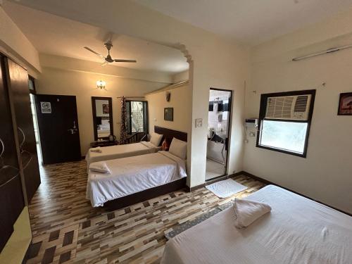 a bedroom with two beds and a mirror at Max Guest House in Agra