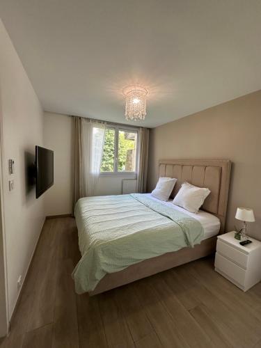 une chambre avec un lit, une fenêtre et une télévision dans l'établissement Grand paris JO24 Expo Park ,CDG , Bourget, Disney,Astérix, à Villepinte