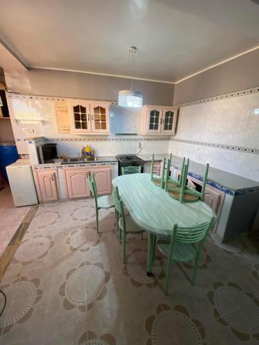 a kitchen with a table and chairs in it at Été in Boumerdes