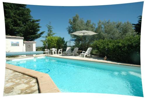 une piscine avec des chaises et un parasol dans l'établissement Le Moulin du Christ, à Peyrefitte-sur-lʼHers