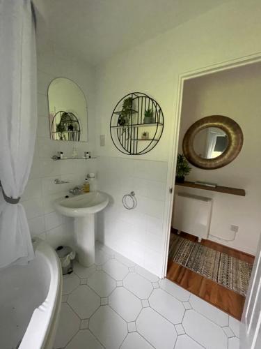 a white bathroom with a sink and a mirror at Gleneagles Rental in Auchterarder