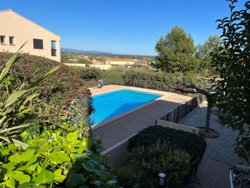 une piscine dans une cour à côté d'une maison dans l'établissement Grand Studio Avec Piscine Presqu'île De Giens, à Hyères