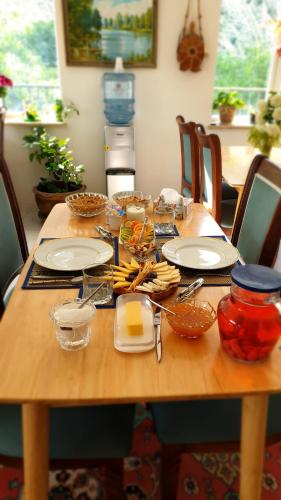 a wooden table with plates and bowls of food on it at Areni Lodge in Areni