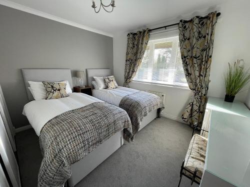 a bedroom with two beds and a window at Gleneagles Rental in Auchterarder