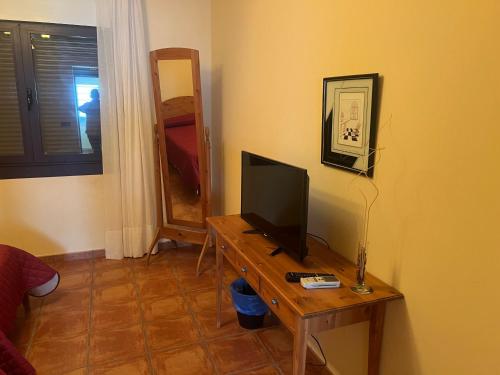 a room with a table with a television on it at Hotel rural La yagona in Entrala