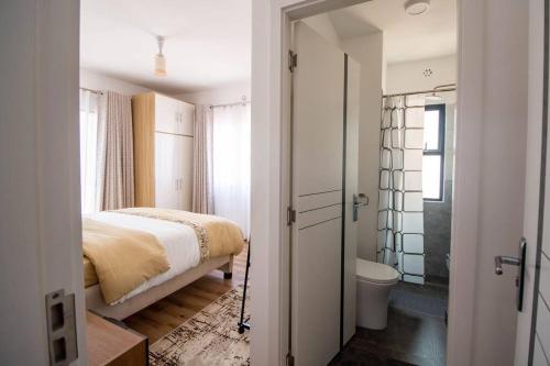a bedroom with a bed and a bathroom with a toilet at BethelHomes in Tatu City