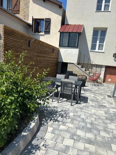 un patio avec une table et des chaises devant un bâtiment dans l'établissement La maison des vignes, à Saint-Dizier