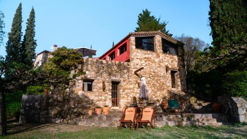 an old stone house with a red roof at Can Serola in Sales del Llierca