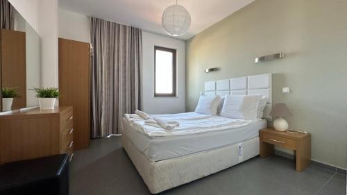 a bedroom with a bed with white sheets and pillows at Sozopol Paradise view in Sozopol