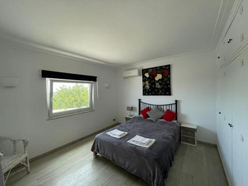 a bedroom with a bed and a window at Casa vista dos cerros in Loulé