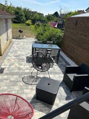 un patio avec une table et des chaises sur un patio dans l'établissement La maison des vignes, à Saint-Dizier