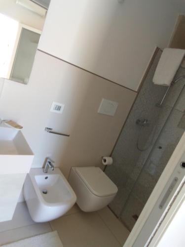 a bathroom with a sink and a toilet and a shower at Rescio's Rooms in Cavallino di Lecce