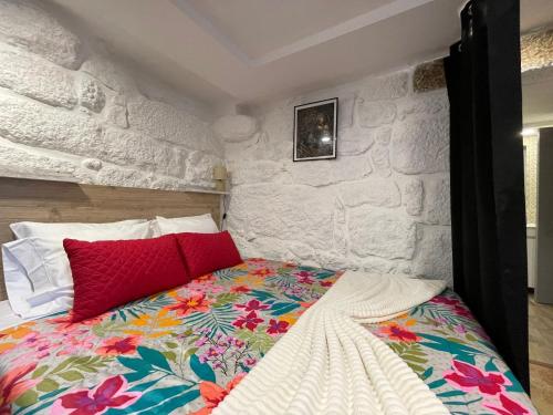 ein Schlafzimmer mit einem Bett mit einer Steinwand in der Unterkunft Casa Pereira in Balança