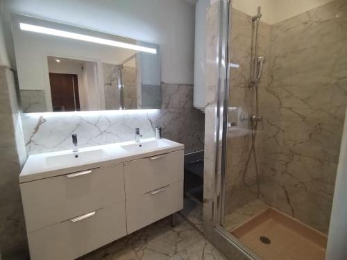 ein Badezimmer mit einem weißen Waschbecken und einer Dusche in der Unterkunft Large flat terrace Sea view, Promenade des Anglais in Nizza