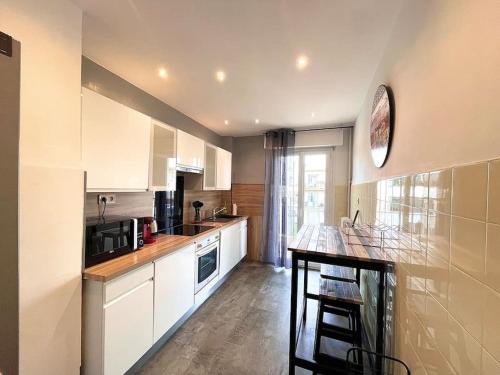 une cuisine avec des armoires blanches et un comptoir dans l'établissement Large flat terrace Sea view, Promenade des Anglais, à Nice