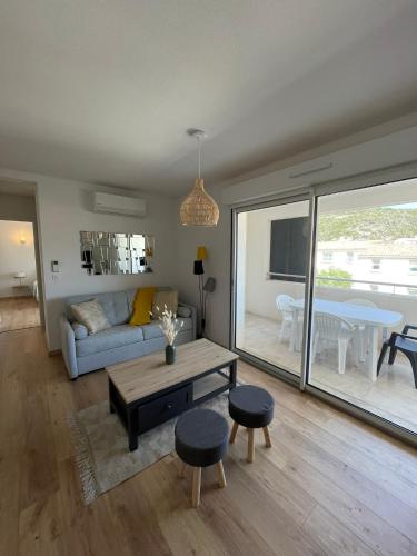un salon avec un canapé et une table dans l'établissement T2 neuf port de Bonifacio avec parking privé, à Bonifacio