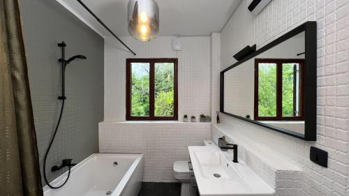 a bathroom with a tub and a sink and a mirror at Villa Concordia in Budva