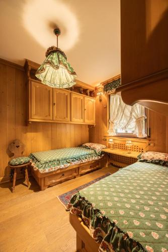 a bedroom with two beds and a chandelier at Casa Cinque Torri in Cortina dʼAmpezzo